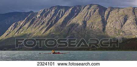 Kayaker on Kusawa Lake with the setting sun hitting the mountains; Yukon, Canada View Large Photo Image Stock Image - Kayaker on Kusawa Lake with the setting sun hitting the mountains; Yukon, Canada. Fotosearch