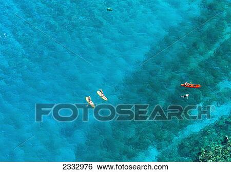 Stock Photograph - Kayakers and stand up paddleboarders over tropical reef; Makena, Maui, Hawaii, United States of America. Fotosearch