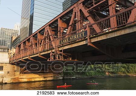 Stock Image - Kayakers In The Chicago River Paddling Under Lake Street Bridge; Chicago Illinois United States Of America. Fotosearch