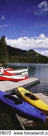 Stock Image - Kayaks On Pier On Lake Beauvert. Fotosearch