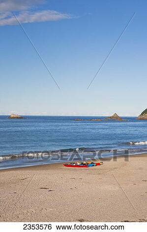 Stock Photograph - Kayaks Sitting On Hahei Beach On The Coromandel Peninsula; Hahei, New Zealand. Fotosearch