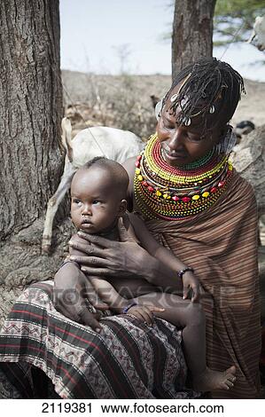 Stock Image - Kenya, Portrait of traditionally dressed Turkana woman and child on Lake Turkana; Loyangalani. Fotosearch