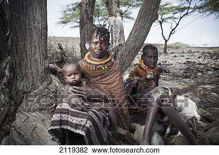 Stock Image - Kenya, Portrait of traditionally dressed Turkana women and child on Lake Turkana; Loyangalani. Fotosearch