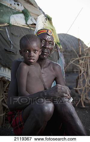 Stock Photo - Kenya, Portrait of traditionally dressed Turkana man with child on Lake Turkana; Loyangalani. Fotosearch