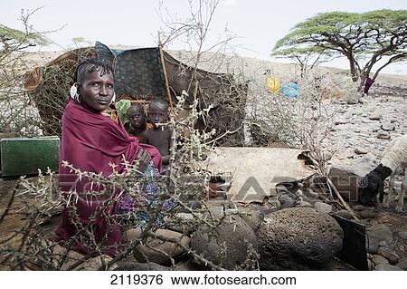 Stock Photograph - Kenya, Portrait of traditionally dressed Turkana woman and children on Lake Turkana; Loyangalani. Fotosearch