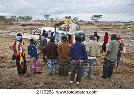 Stock Image - Kenya, View of people standing next to matatu (minibus taxi); North Turkana. Fotosearch