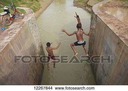 Kids jumping off dam; Battambang, Cambodia View Large Photo Image Picture - Kids jumping off dam; Battambang, Cambodia. Fotosearch