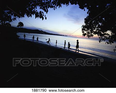 Stock Image - Kids Playing Football On Grand Anse Beach. Fotosearch
