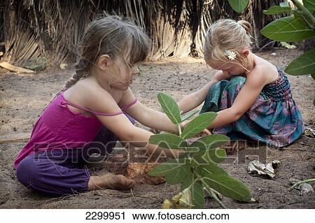 Stock Image - Kiki Lett and Isla Reynolds play together, on Turtle Beach, Goa, India.. Fotosearch