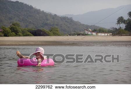 Kiki Lett floats on a ring in the safe shallow waters of an estuary on holiday in India, Palolem Beach, Goa, India. View Large Photo Image Stock Image - Kiki Lett floats on a ring in the safe shallow waters of an estuary on holiday in India, Palolem Beach, Goa, India.. Fotosearch