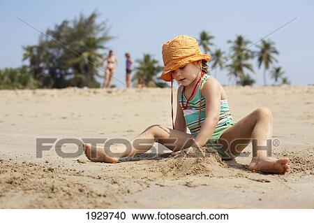 Stock Image - Kiki Lett makes sandcastles on holiday in India, Turtle Beach, Goa, India.. Fotosearch