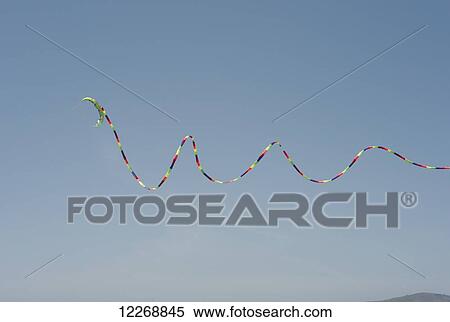 Kite with a very long tail spirals against a blue sky, San Francisco, California, USA View Large Photo Image Stock Photography - Kite with a very long tail spirals against a blue sky, San Francisco, California, USA. Fotosearch