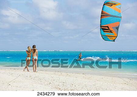 Stock Photo - Kiteboarding in the lagoon over tropical blue water; Bora Bora, French Polynesia. Fotosearch
