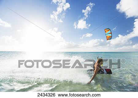 Stock Photograph - Kiteboarding in tropical lagoon in the South Pacific; Tikehau, French Polynesia. Fotosearch