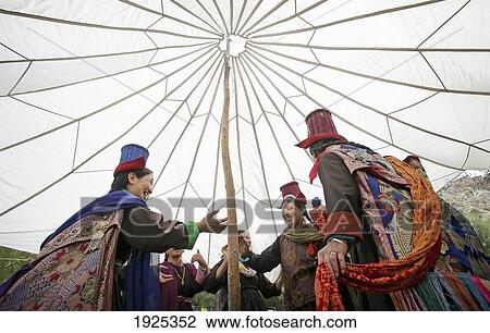 Stock Image - Ladakhi Women In Traditional Dress And Hats Dancing Under A Traditional Marquee, Leh, Ladakh, Indian Himalayas, India. Fotosearch