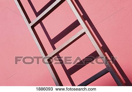 Stock Image - Ladder Leaning Against Red Building. Fotosearch