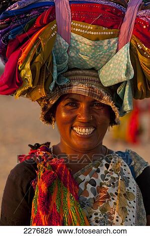 Lady Selling Indian Cloth On The Beach At Dusk, Candolim, Goa, India. View Large Photo Image Stock Photo - Lady Selling Indian Cloth On The Beach At Dusk, Candolim, Goa, India.. Fotosearch