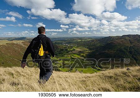 Lake District, Cumbria, Uk. Walker Going Down Hill With View Looking Along Langdale From Near Chapel Stile View Large Photo Image Stock Photography - Lake District, Cumbria, Uk. Walker Going Down Hill With View Looking Along Langdale From Near Chapel Stile. Fotosearch