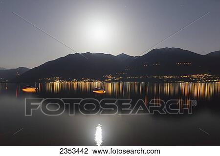 Stock Image - Lake Maggiore And The Swiss Alps Illuminated By Moonlight At Night; Locarno, Ticino, Switzerland. Fotosearch