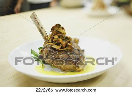 Stock Photography - Lamb chop on a plate in a restaurant; boston massachusetts usa. Fotosearch