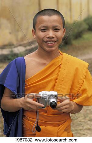 Laos, Vientiane, Si Saket Temple, Portrait Of Young Monk Holding Camera. View Large Photo Image Stock Image - Laos, Vientiane, Si Saket Temple, Portrait Of Young Monk Holding Camera.. Fotosearch