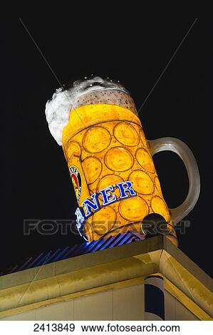 Stock Photo - Large beer mug on top of a building illuminated at nighttime; Munich, Germany. Fotosearch