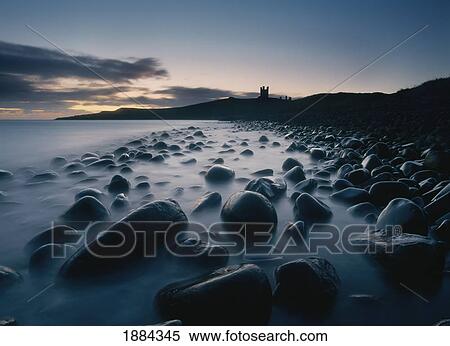 Stock Photography - Large Boulders On Beach Near Dunstanburgh Castle At Dawn. Fotosearch