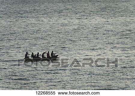Stock Photography - Large dugout canoe leaving Cape Maclear in the evening, Lake Malawi; Malawi. Fotosearch