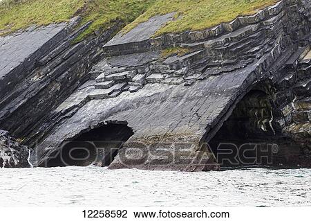 Stock Image - Large rock cave at water's edge in cliff side; Ballybunion, County Kerry, Ireland. Fotosearch
