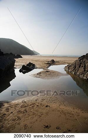 Stock Image - Large Rock Pool On The Beach Surrounded By Rocks In Putsborough Sands, North Devon, Uk. Fotosearch