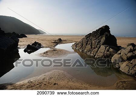 Large Rock Pool On The Beach Surrounded By Rocks In Putsborough Sands, North Devon, Uk View Large Photo Image Stock Photo - Large Rock Pool On The Beach Surrounded By Rocks In Putsborough Sands, North Devon, Uk. Fotosearch