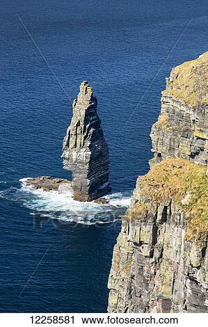 Stock Image - Large sea stack rock structure in the ocean with cliffs; Liscannor, County Clare, Ireland. Fotosearch