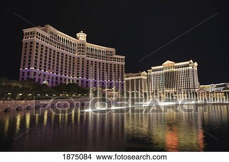 Picture - Las Vegas, Nevada, United States Of America; Hotels Illuminated At Night Reflecting In The Water Fountain Pool. Fotosearch