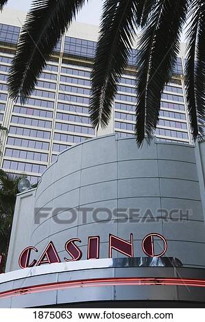 Stock Image - Las Vegas, Nevada, United States Of America; Neon Casino Sign In Front Of A Hotel And Palm Trees. Fotosearch