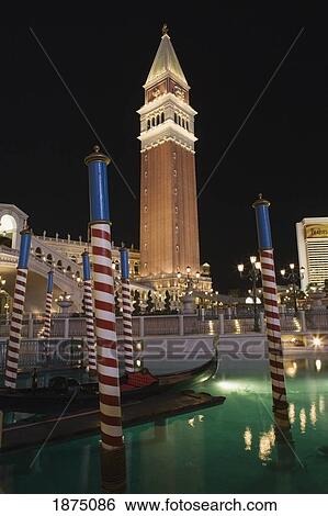 Stock Photograph - Las Vegas, Nevada, United States Of America; San Marco's Tower Illuminated At Night With Striped Poles And A Canal. Fotosearch