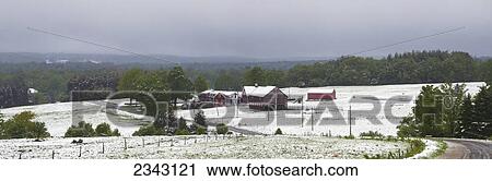 Stock Image - Late Spring Snowfall On A Farm With A Red Barn; Ville De Lac Brome, Quebec, Canada. Fotosearch