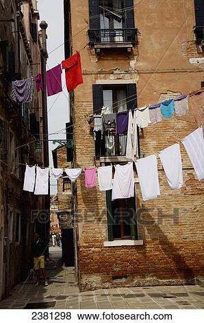 Stock Photo - Laundry hanging on clotheslines over a street in Giardini area; Venice, Italy. Fotosearch