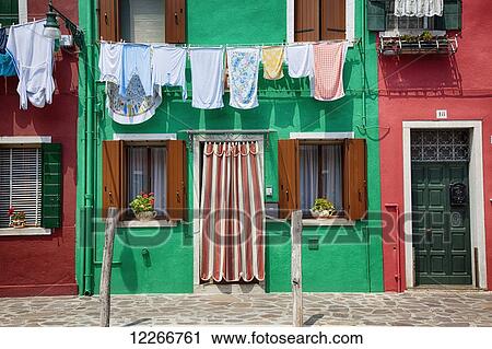 Laundry hangs in front of a row of colourful houses; Burano, Venice, Italy View Large Photo Image Stock Image - Laundry hangs in front of a row of colourful houses; Burano, Venice, Italy. Fotosearch