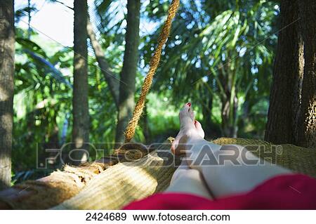 Stock Photo - Laying barefoot in a hammock; Ulpotha, Embogama, Sri Lanka. Fotosearch