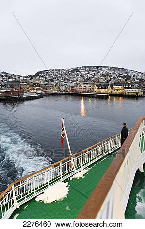 Stock Image - Leaving the harbour of Harstad onboard the Hurtigruten ship MS Nordlys, the largest town on the Vesteralen Islands; Norway. Fotosearch