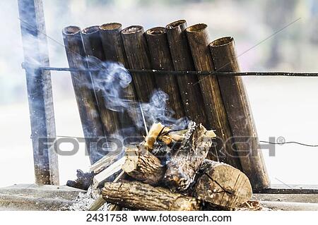 Stock Photo - Lemang, traditional Indonesian food made of glutinous rice, coconut milk and salt that is cooked in a hollowed bamboo stick lined with banana leaves, Simalungun, North Sumatra, Indonesia. Fotosearch