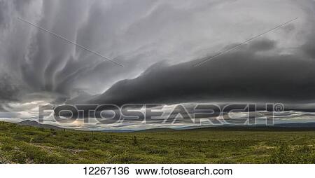 Stock Photograph - Lenticular clouds form over the flanks of Crow Mountain; Old Crow, Yukon, Canada. Fotosearch