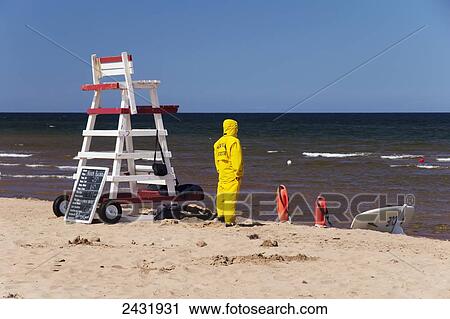 Stock Image - Lifeguard dressed in yellow head to toe; North Rustico, Prince Edward Island, Canada. Fotosearch