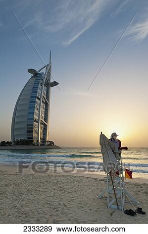 Stock Photo - Lifeguard On Beach At Dusk In Front Of The Burj Al Arab; Dubai, United Arab Emirates. Fotosearch