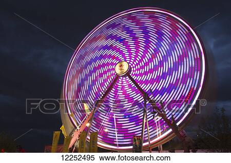 Stock Photography - Light effect of a fairground ride at night at the Calgary Stampede; Calgary, Alberta, Canada. Fotosearch
