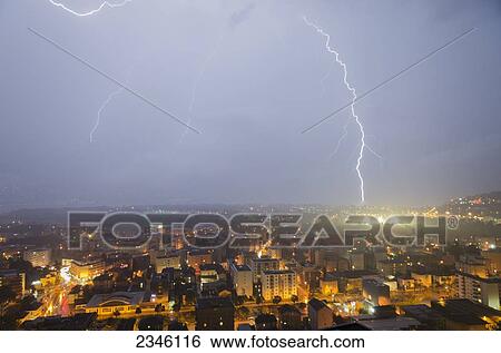 Stock Photograph - Lightening Strikes Over A City; Locarno, Ticino, Switzerland. Fotosearch