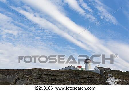 Lighthouse on cliff's edge with dramatic clouds and blue sky; Kilcredaun, County Clare, Ireland View Large Photo Image Stock Photograph - Lighthouse on cliff's edge with dramatic clouds and blue sky; Kilcredaun, County Clare, Ireland. Fotosearch