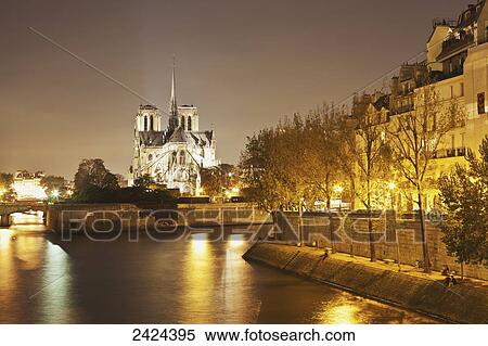 Lights illuminate the river with an illuminated church in the background; Paris, France View Large Photo Image Stock Photography - Lights illuminate the river with an illuminated church in the background; Paris, France. Fotosearch