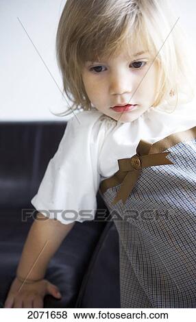 Stock Photo - Little Girl Leaning On A Sofa, Vancouver, British Columbia. Fotosearch