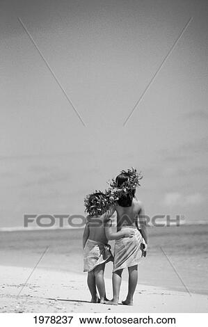 Stock Photo - Little Polynesian Sisters In Haku And Pareo On Beach, View From Behind (Black And White Photograph).. Fotosearch